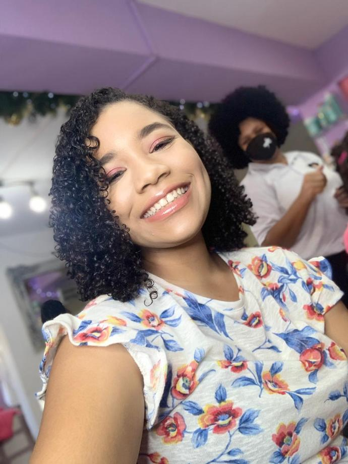Clienta feliz con cabello rizado en Afropoderosas Salón